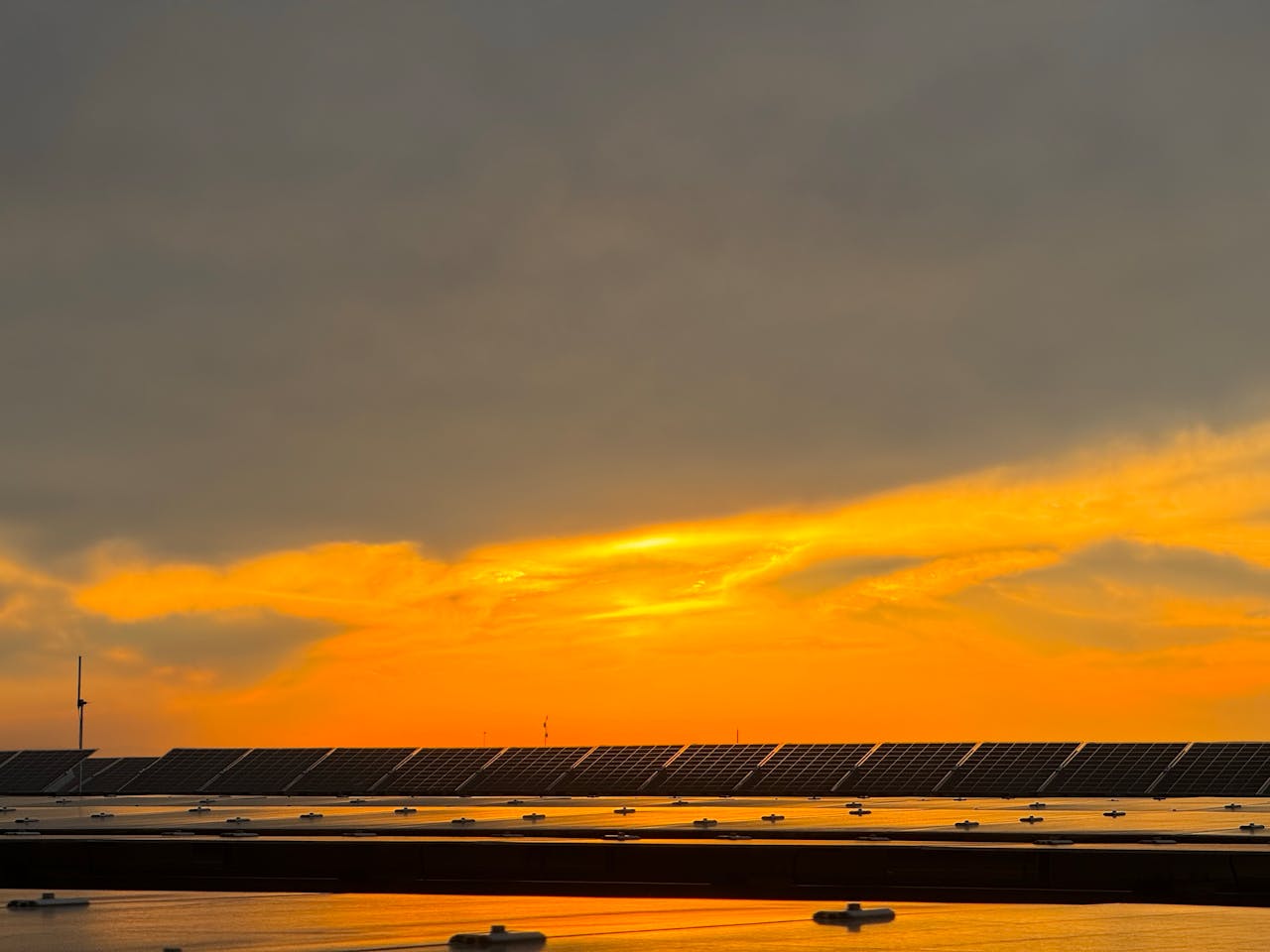 Captivating view of solar panels beneath a vibrant sunset sky in Niğde, Türkiye.